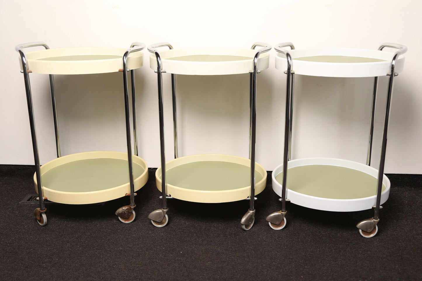 A pair of midcentury plastic bedside tables/drinks trolley with metal castors