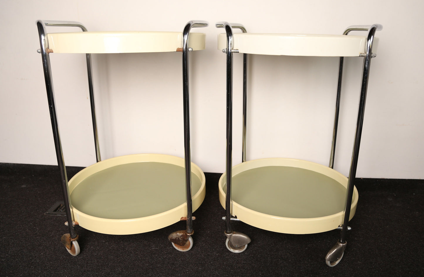 A pair of midcentury plastic bedside tables/drinks trolley with metal castors