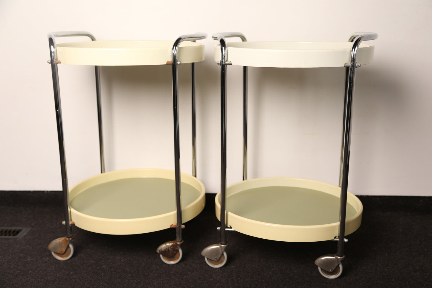 A pair of midcentury plastic bedside tables/drinks trolley with metal castors