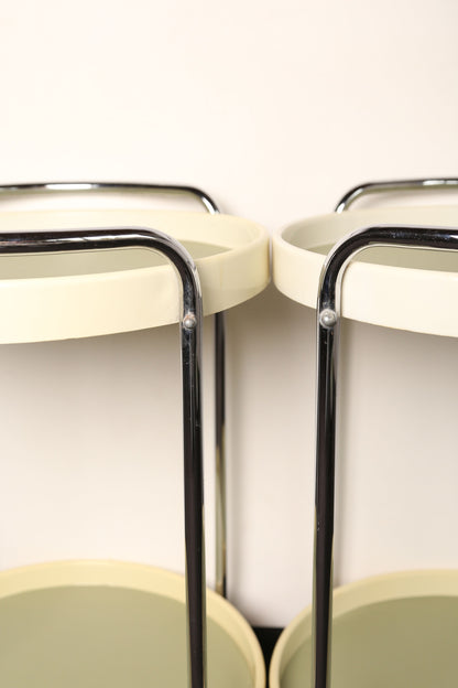 A pair of midcentury plastic bedside tables/drinks trolley with metal castors